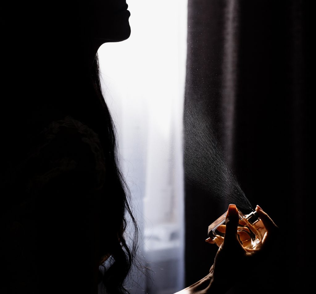 silueta zena koja nanosi parfem